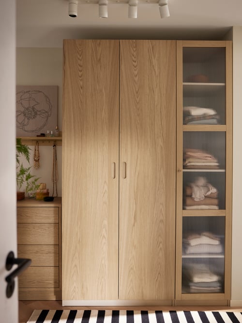 Hallway with a beige PAX wardrobe combination placed next to a TONSTAD chest of 4 drawers and a PJÄTTERYD picture.