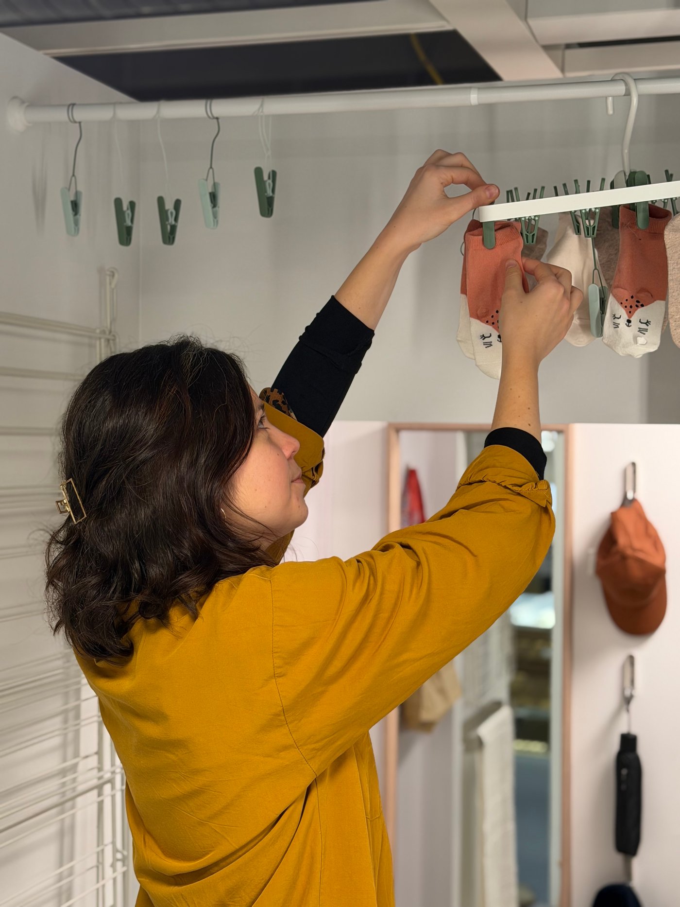 Une femme accrochant des chaussettes à l'air libre dans sa salle de bain