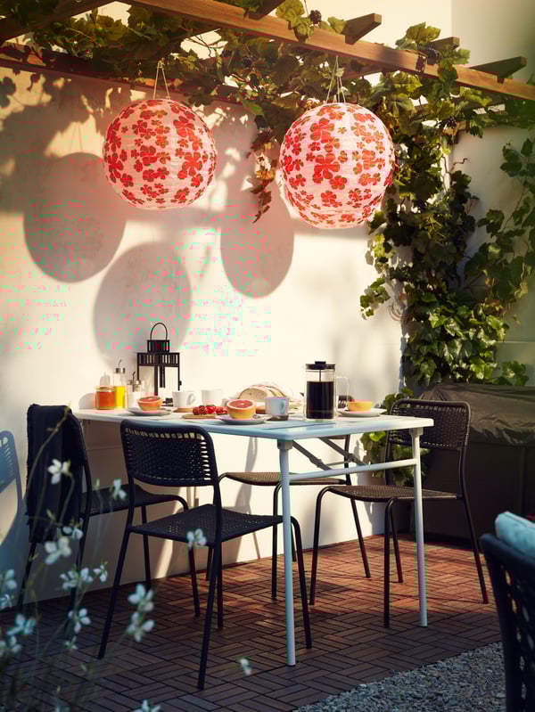 An outdoor dining area with NÄMMARÖ table and seating and FRÖSÖN/DUVHOLMEN chair cushions, and a nearby GRILLSKÄR barbecue.