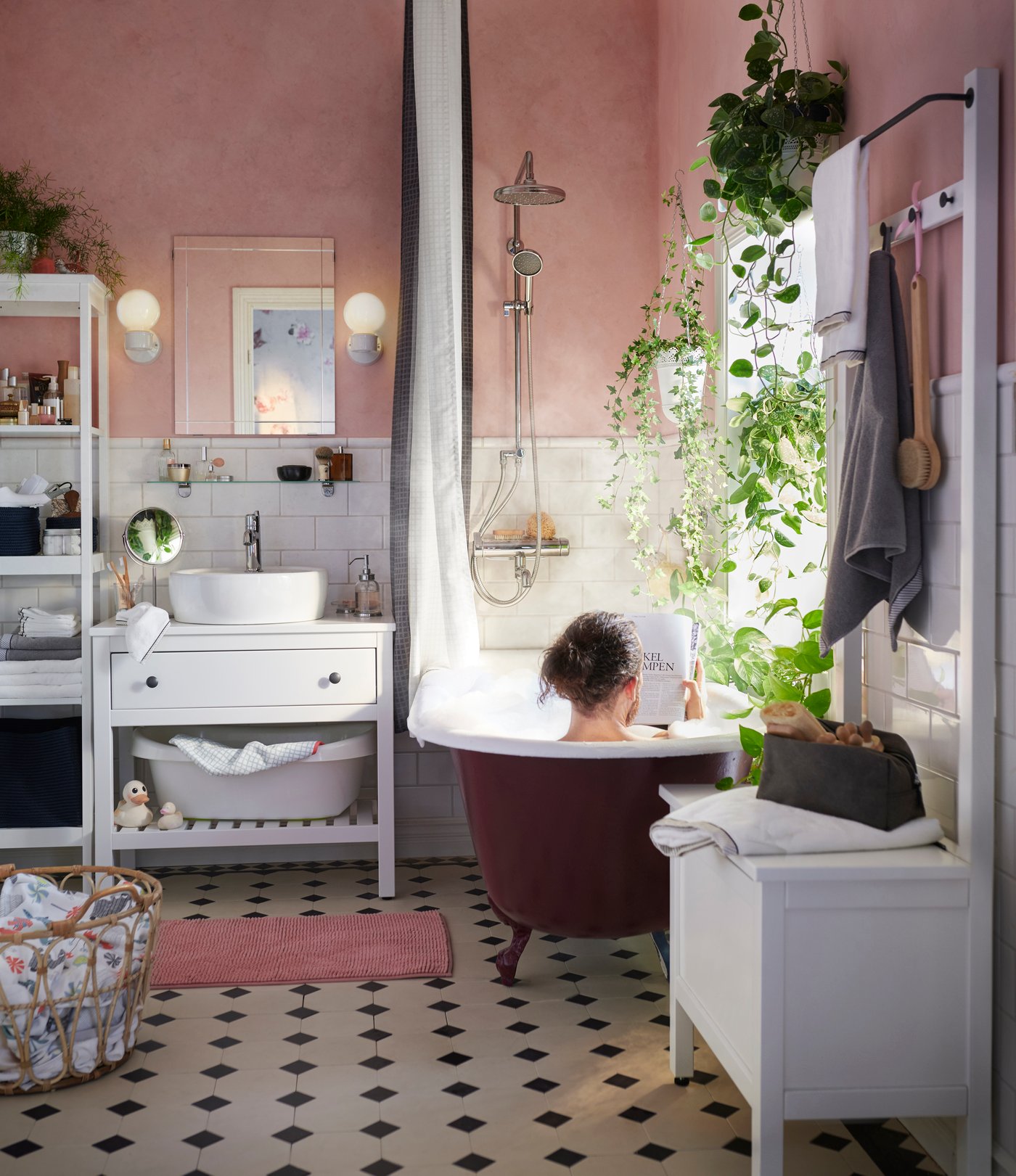 Man in bath in pink bathroom