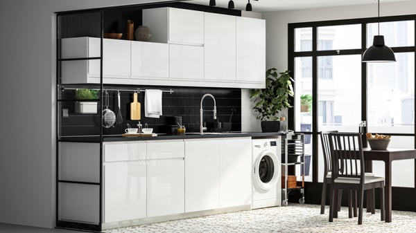 Cuisine blanche et noire ouverte sur l'espace de vie