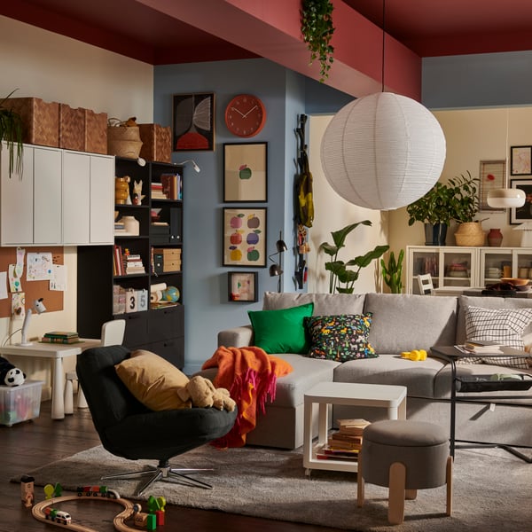 A light living room with a beige/grey BÅRSLÖV 3-seat sofa-bed with chaise longue, surrounded by colourful, playful decor.