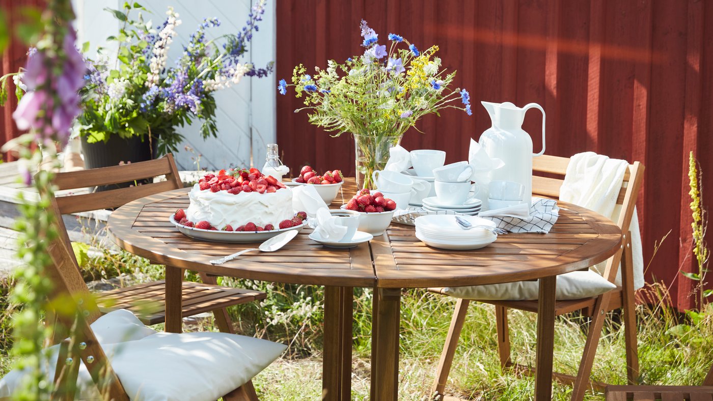 Puutarhaan on katettu NÄMMARÖ-pöydälle kesäisiä herkkuja.