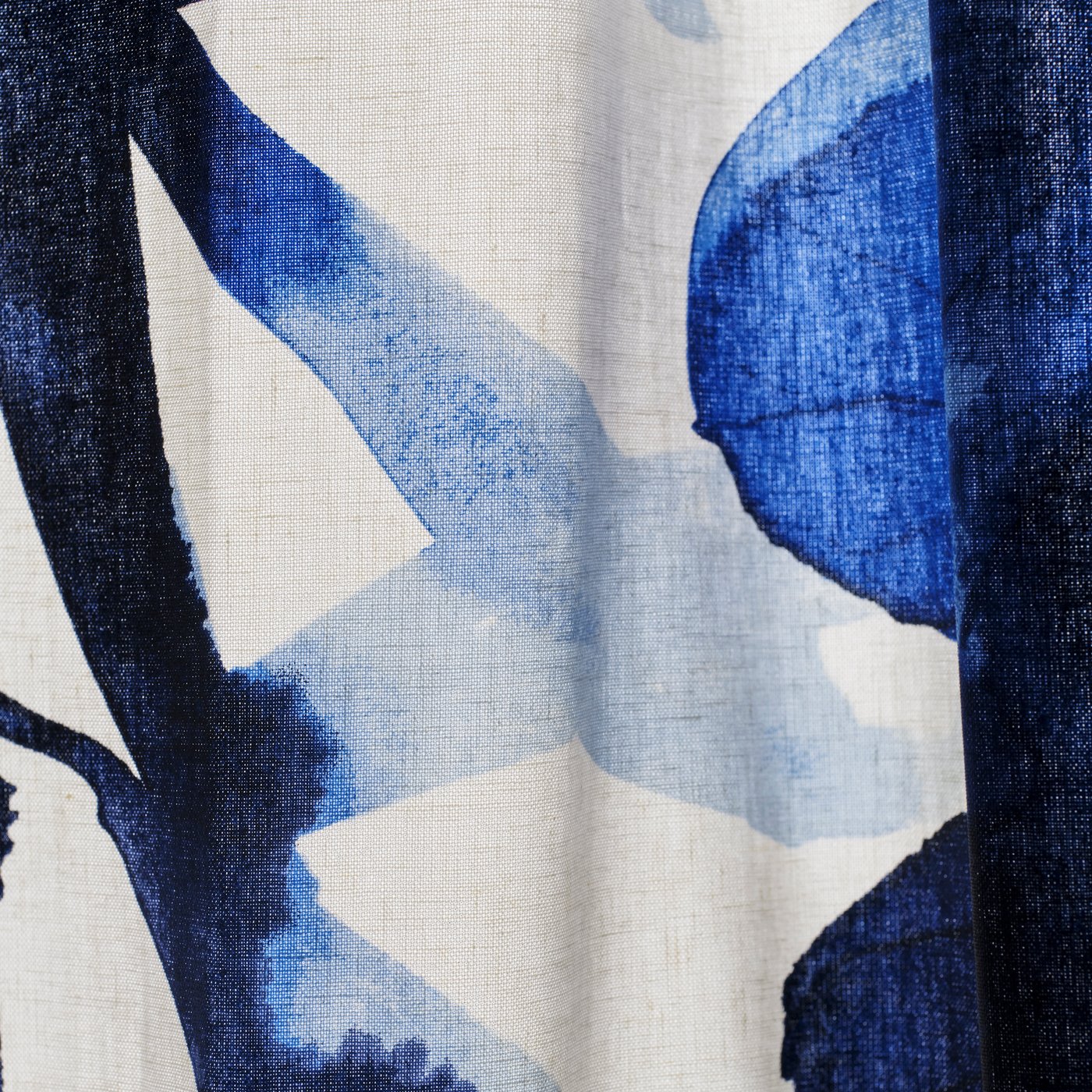 Närbild på en blå- och vitmönstrad gardin. 