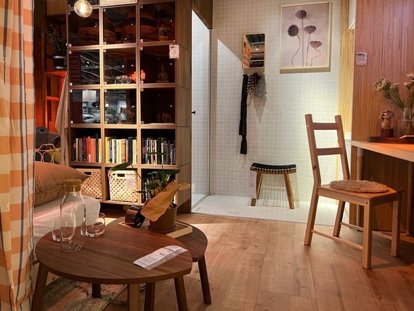 A bedroom with a natural look containing a wooden floor, large wooden cupboard with compartments and wooden side tables