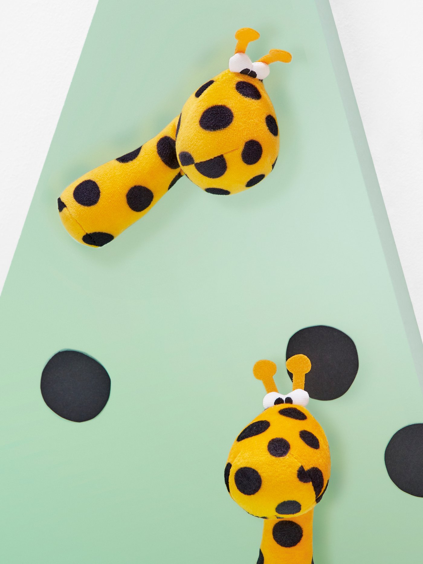 Yellow KLAPPA rattle toy laying on a light green surface.