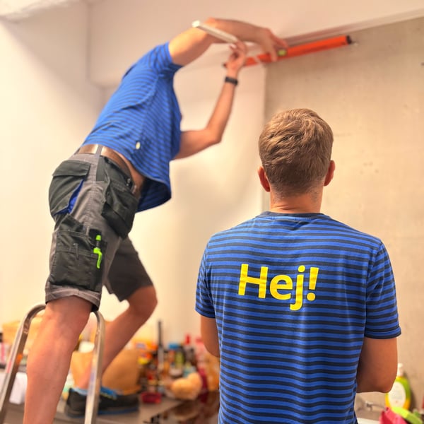 pracownicy mierzą ścianę