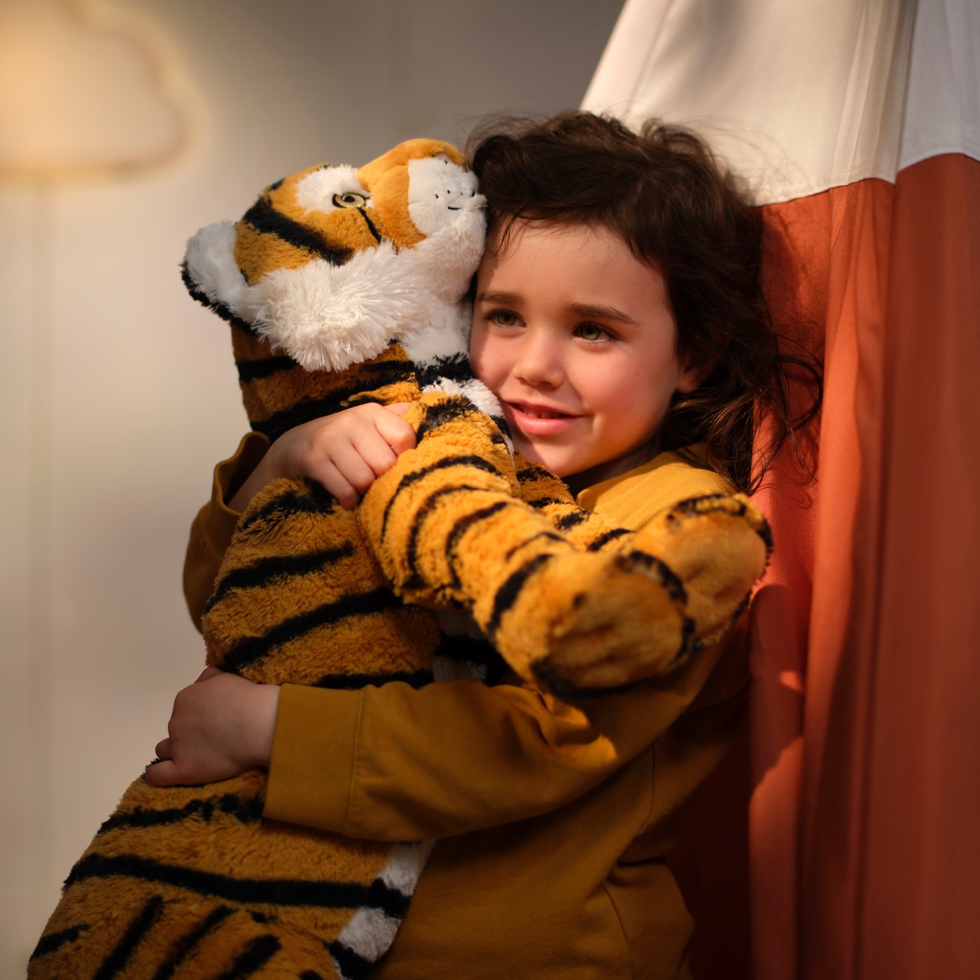 En ALPTALL mjukis föreställande en bengalisk tiger, randig och ljusorange, i barnrummet.