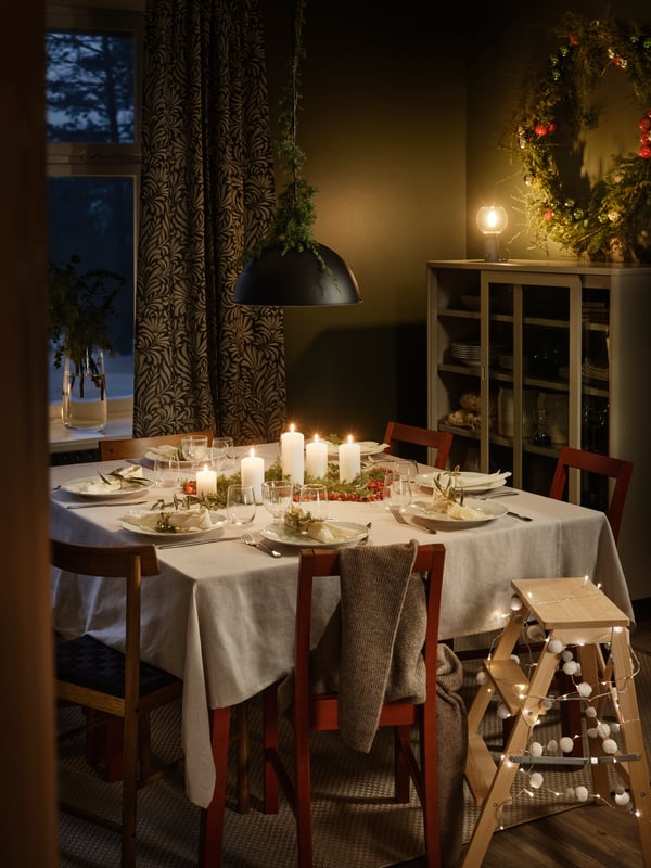 Mesa con mantel blanco con copas STORSINT sobre ella.