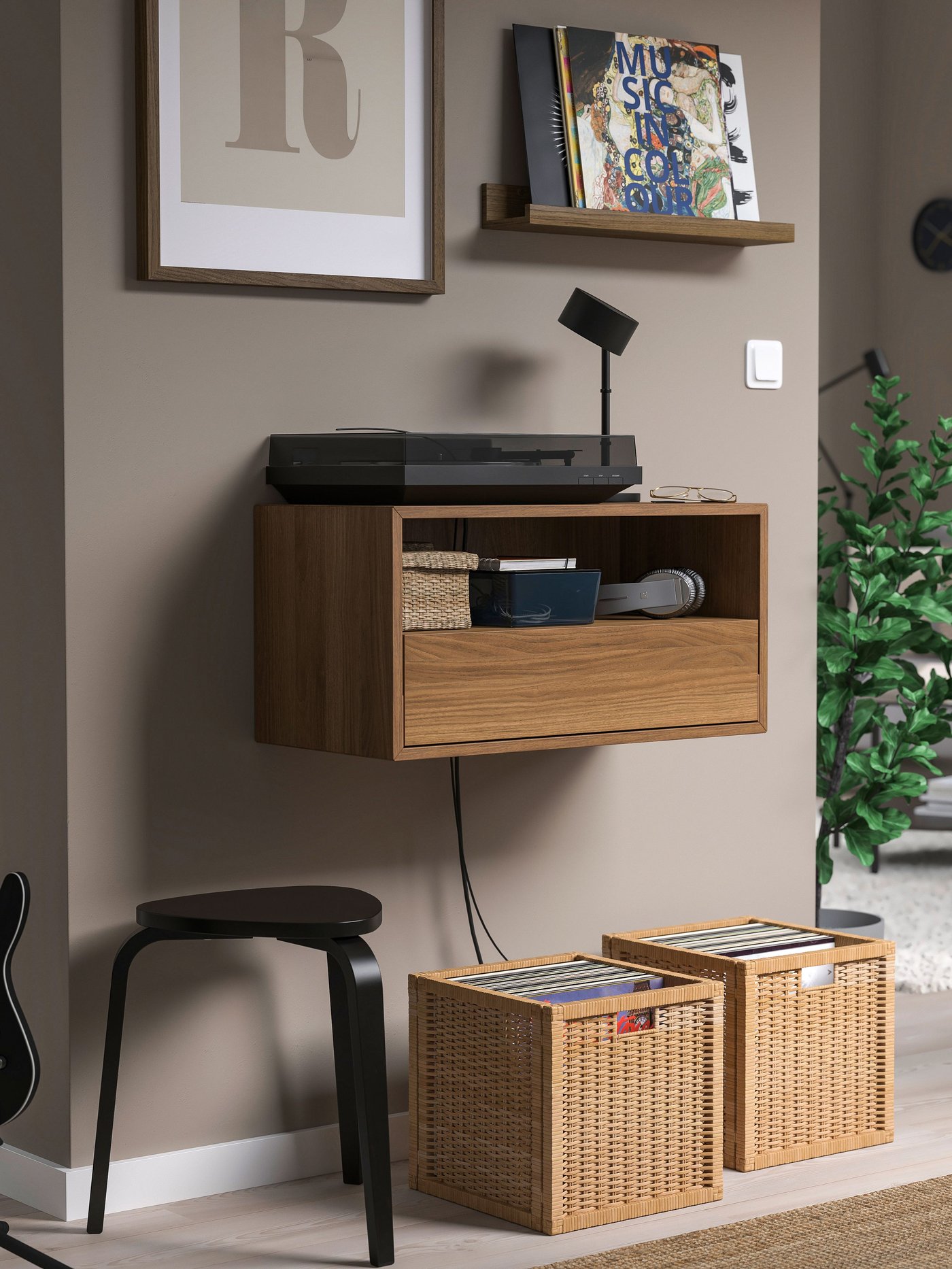 Un mueble flotante EKET con dos canastos en el piso que contienen vinilos.