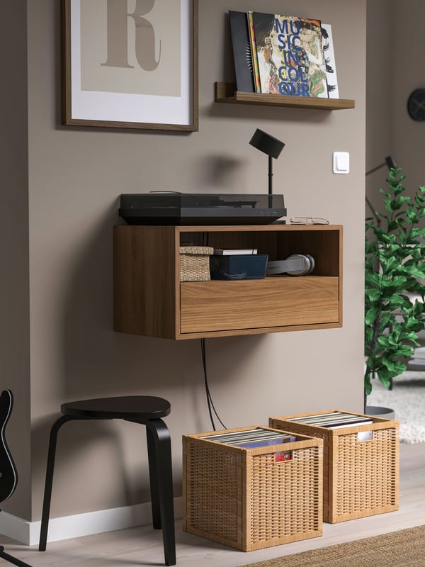 Un mueble flotante EKET con una puerta en la parte inferior organia un tocadiscos en un living.