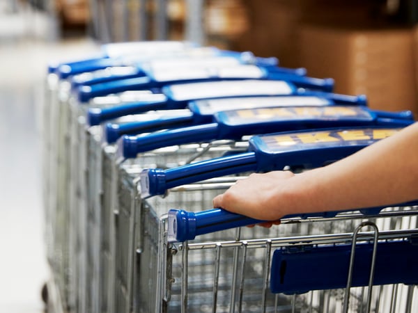 Een rij IKEA winkelkarren die door een IKEA winkel worden geduwd.