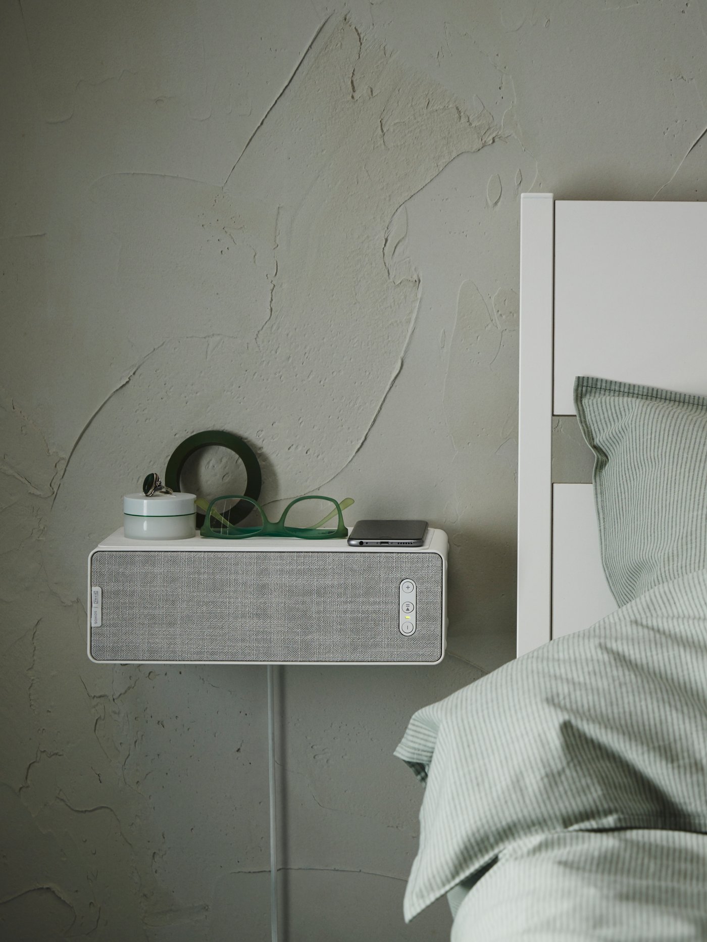 A white SYMFONISK bookshelf speaker wall bracket in the bedroom