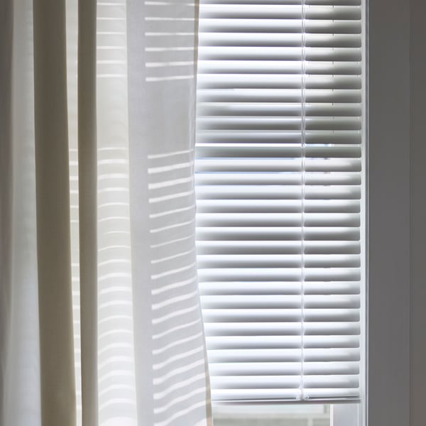 A white VECKLARFLY Venetian blind in the bedroom