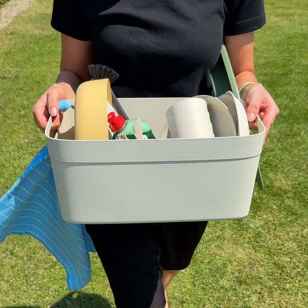 Someone is carrying a SPJUTLILJA washing-up bowl containing a MARULK picnic set.