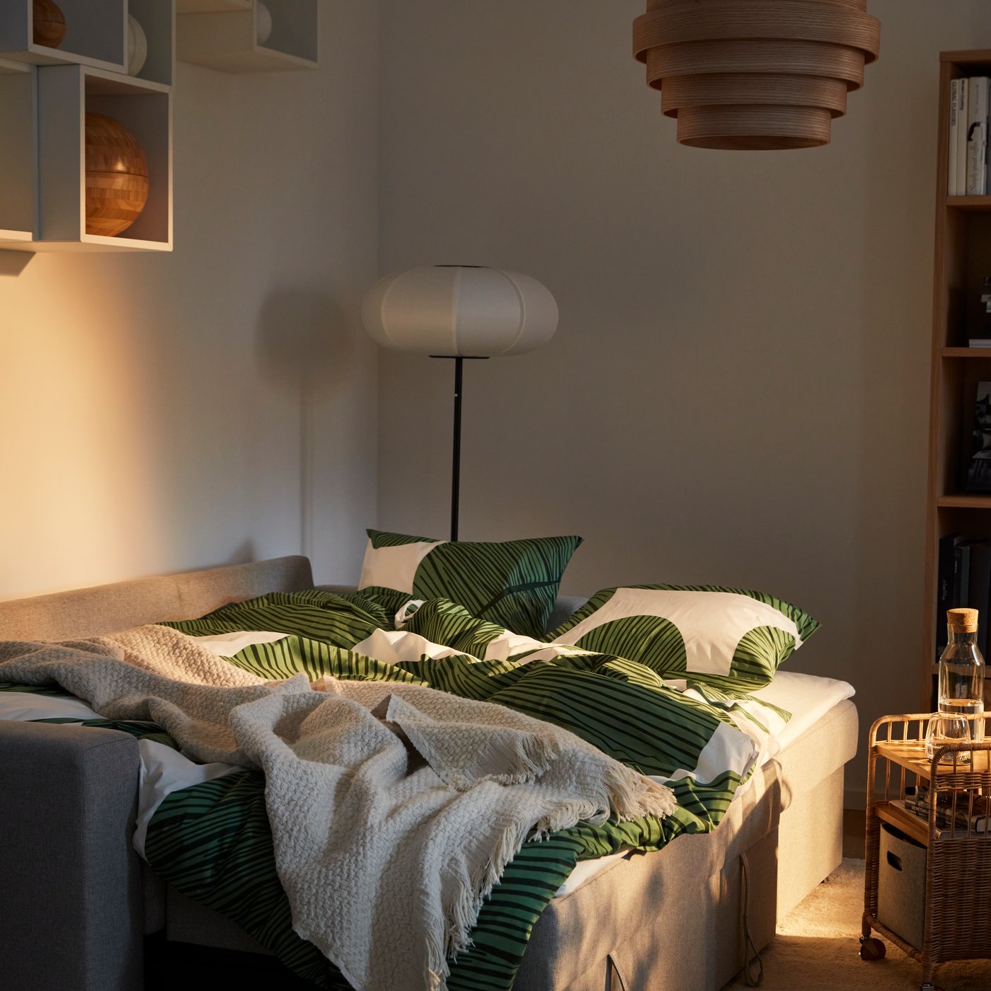 Vardagsrum med beige bäddsoffa som bäddas ut till dubbelsäng med KUNGSCISSUS påslakan och örngott.