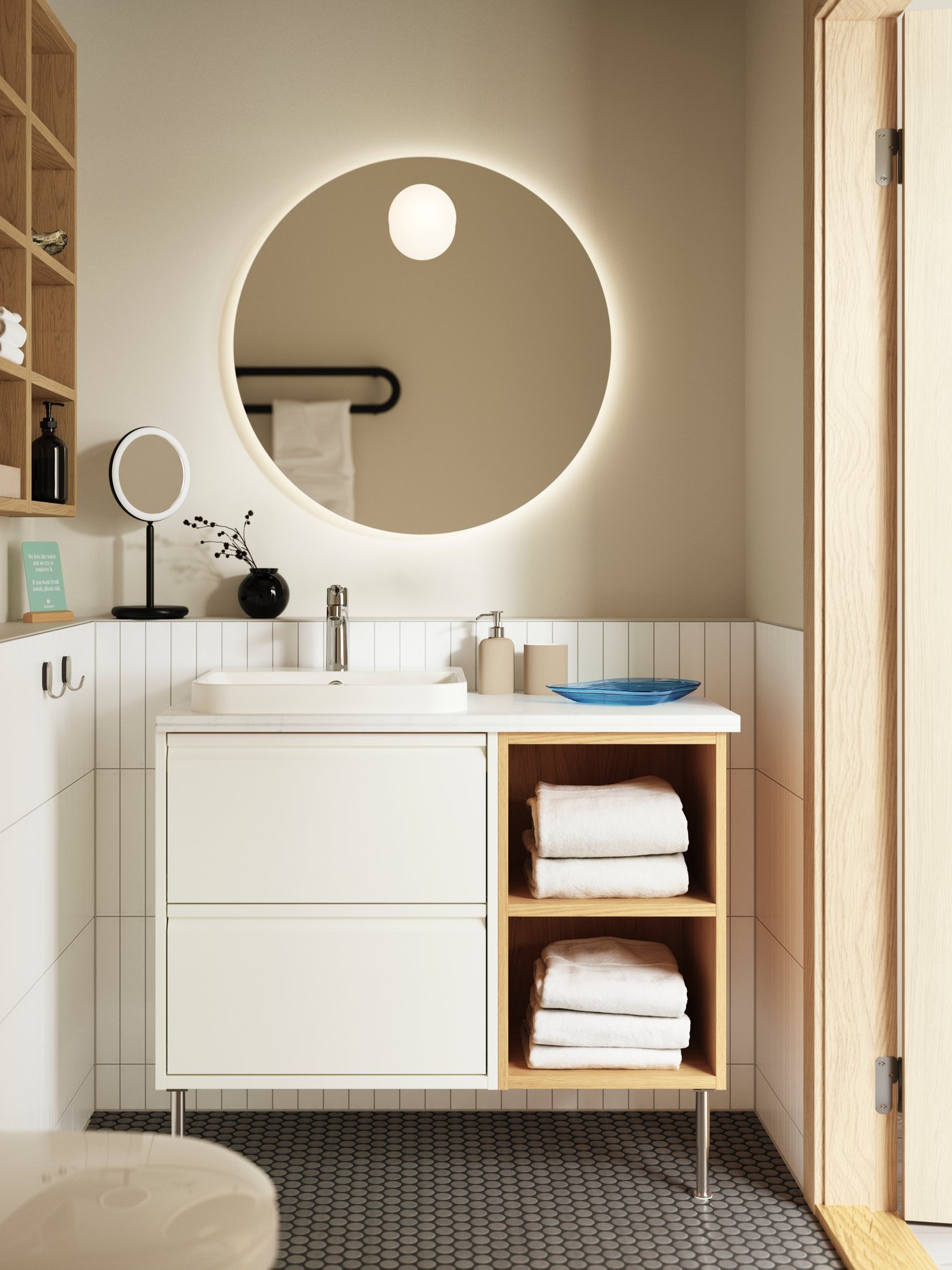 A white-tiled, beige-walled bathroom has an ÄNGSJÖN wash-stand with high gloss white drawers and oak effect open cabinets.