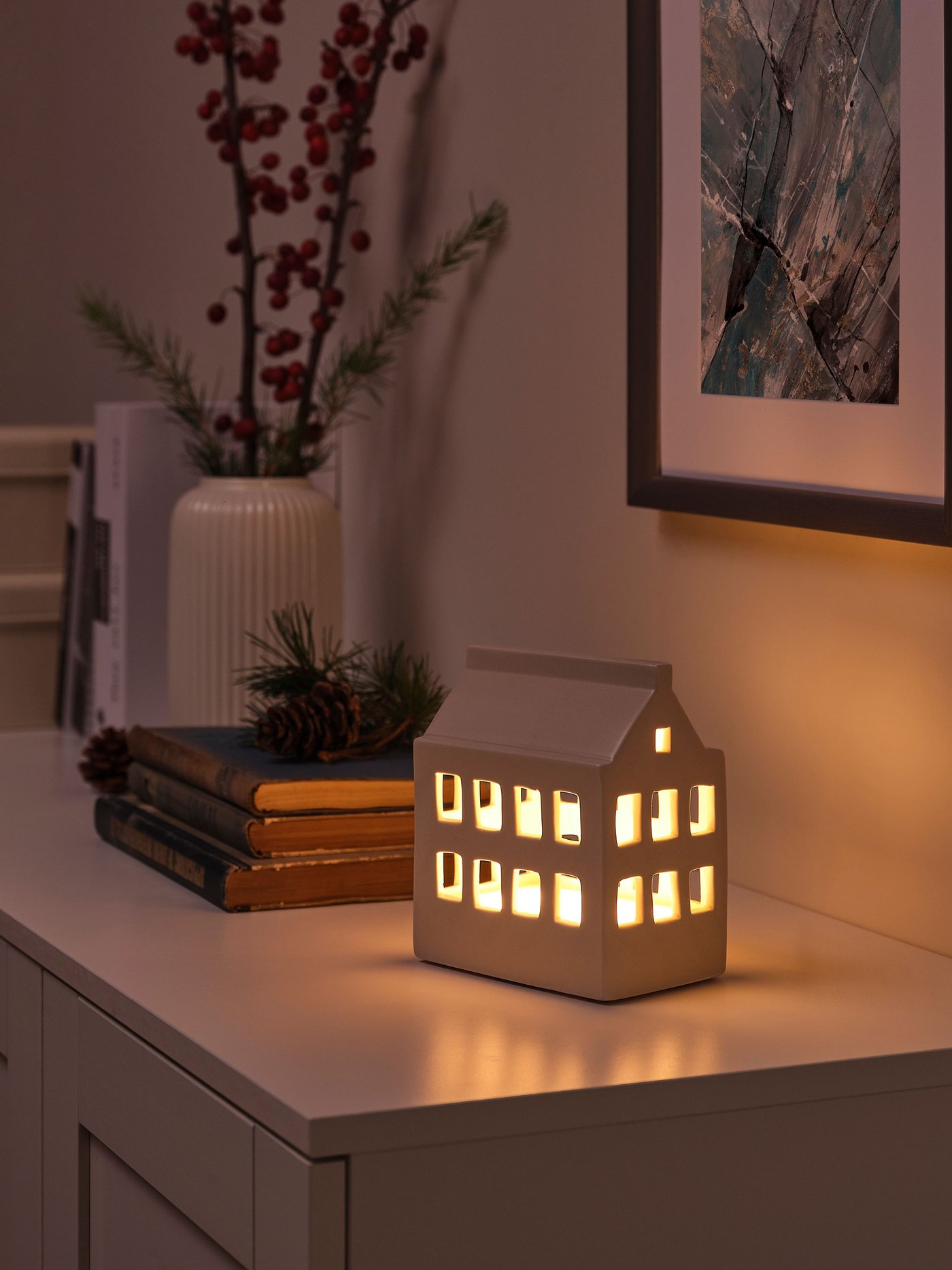 Beleuchtete Tischdekoration in Form eines weißen Keramik Hauses aus unserer STRÅLA Serie.