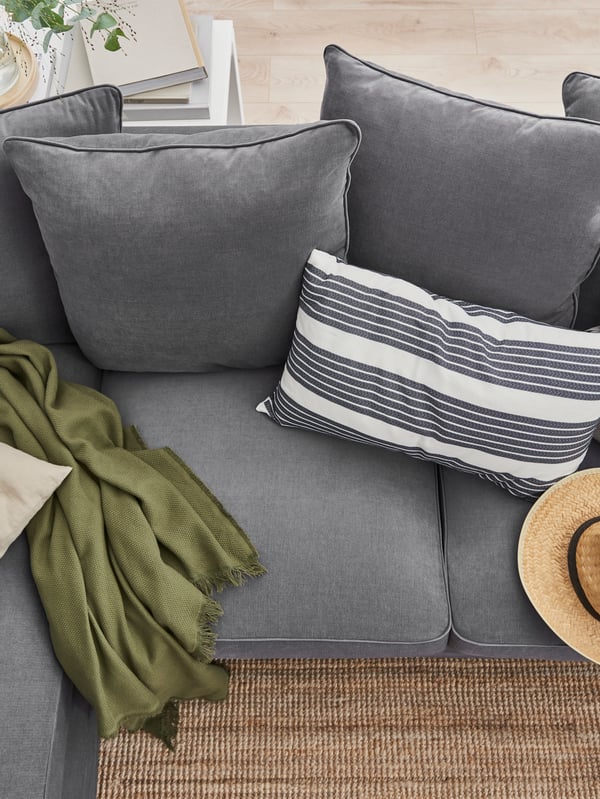 GRÖNLID three-seat sofa with chaise lounge and a cushion with a METTALISE cover.