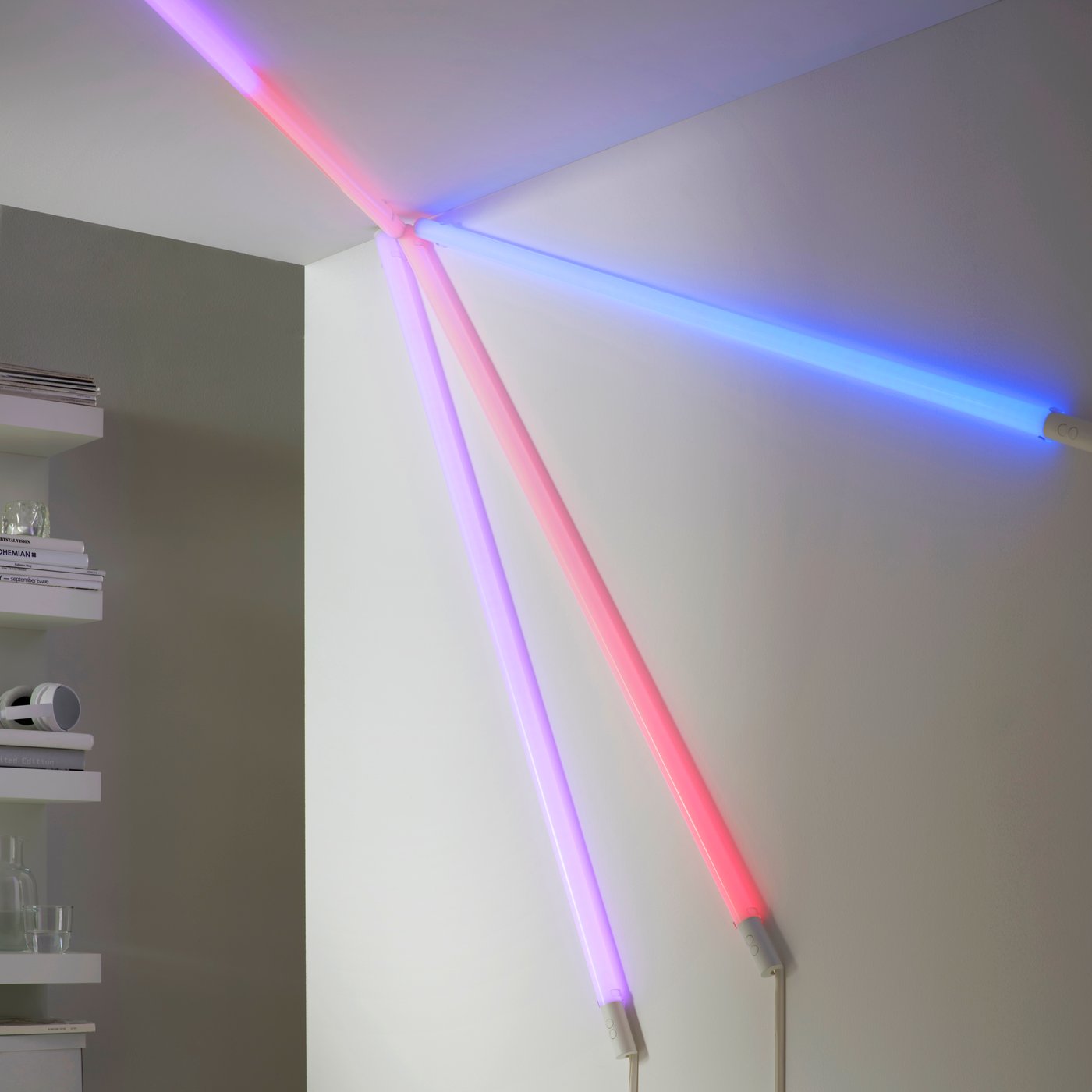Four FÖRLIG LED floor/wall lamps mounted together in a pattern on a wall and in a ceiling, all glowing in different colours.
