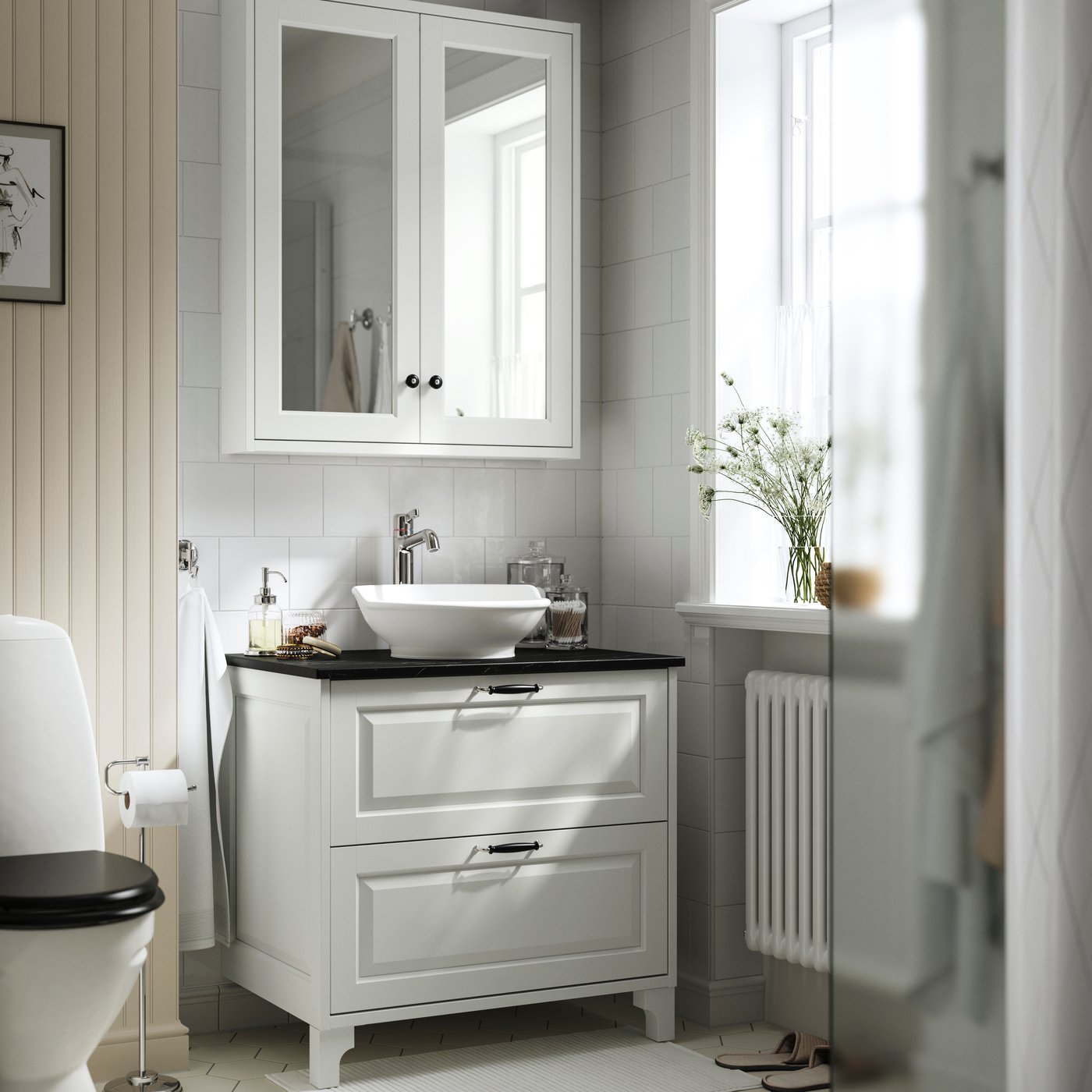 Ein weißer/schwarzer TÄNNFORSEN Waschtischunterschrank in Marmoroptik mit Schubladen, Waschbecken und Armatur.