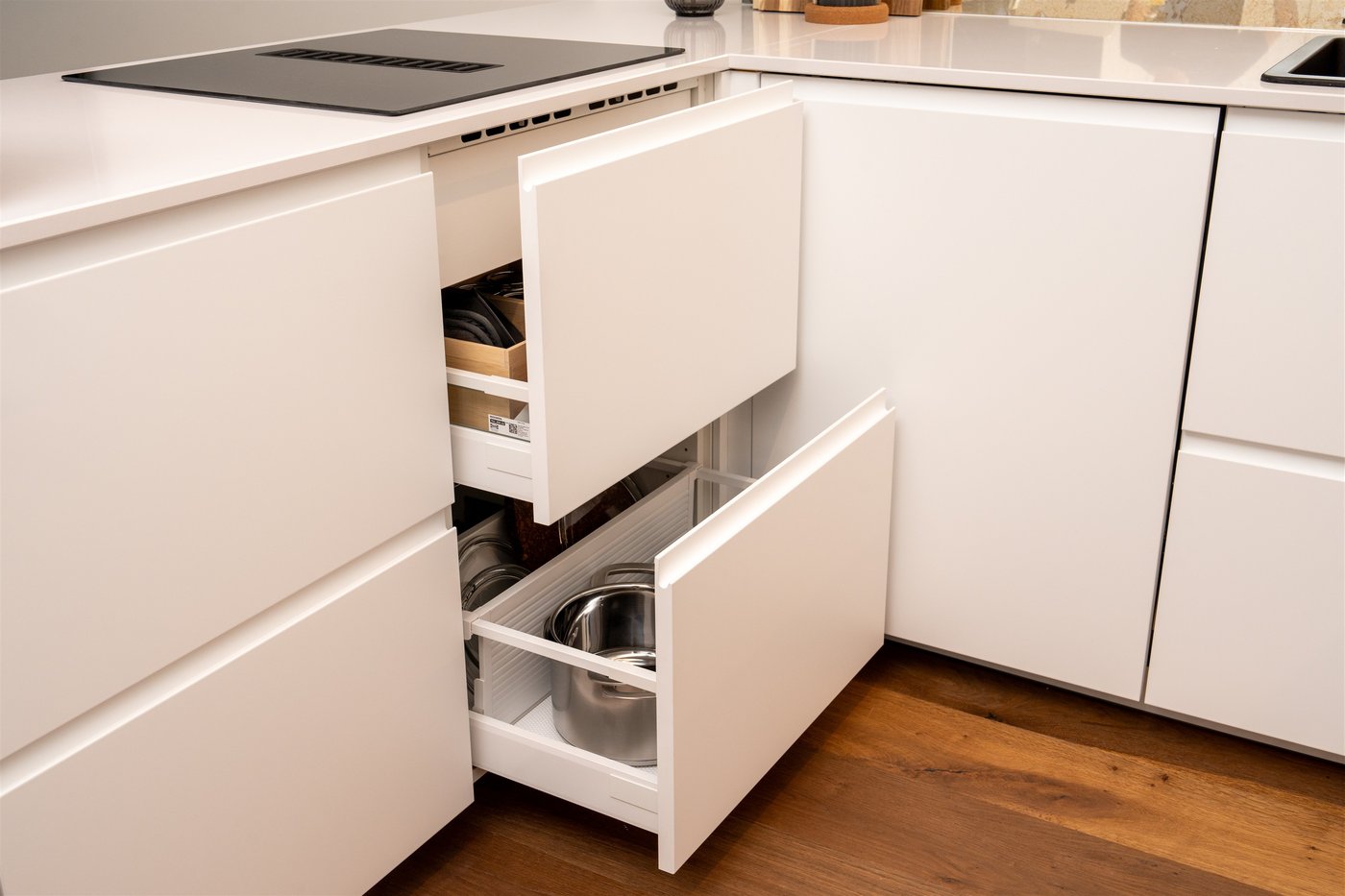 Zwei geöffnete Schubladen in einer IKEA Küche mit matten weißen Fronten