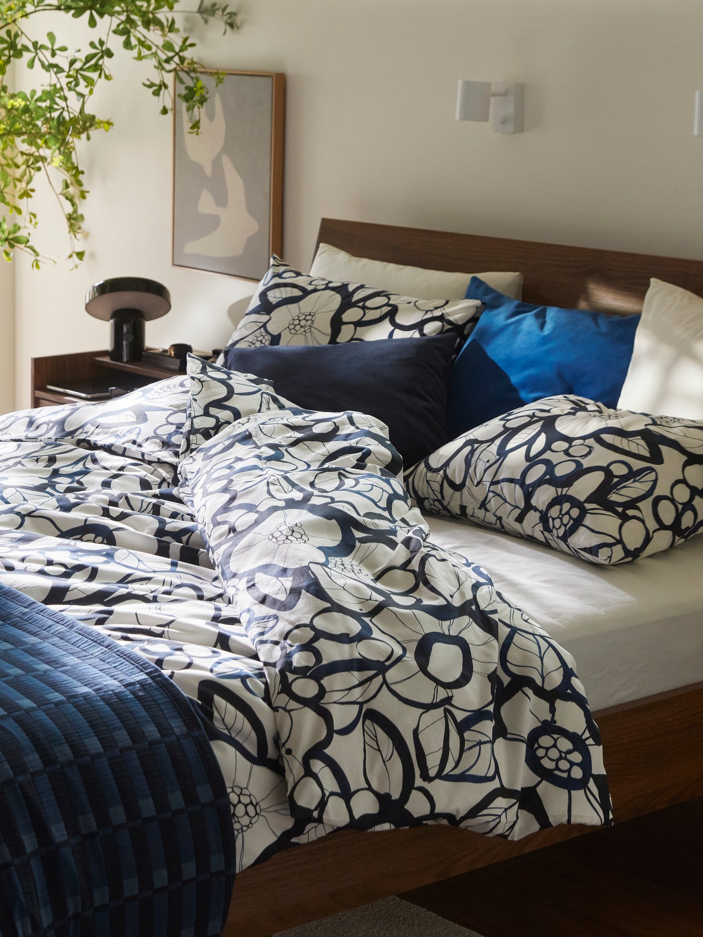 A dark blue SANELA cushion cover in the bedroom