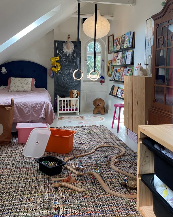 Ein Kinderzimmer mit Spielzeug, Turnringen, Boxen für Aufbewahrung.