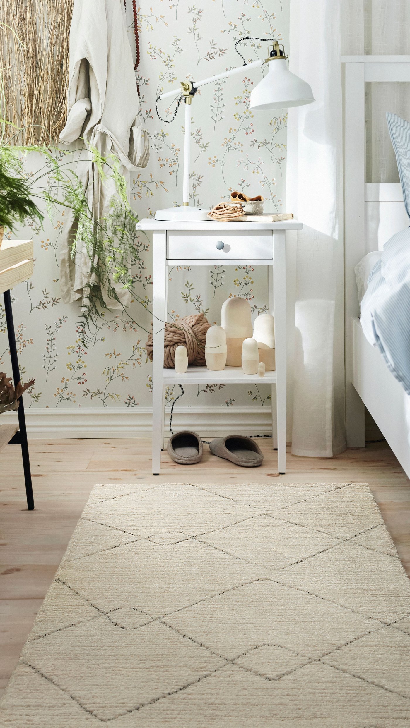 Valkoinen TVERSTEDT-matto makuuhuoneen lattialla. Takana HEMNES valkoinen yöpöytä.
