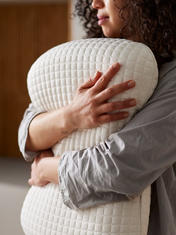 A person holding an ergonomic pillow