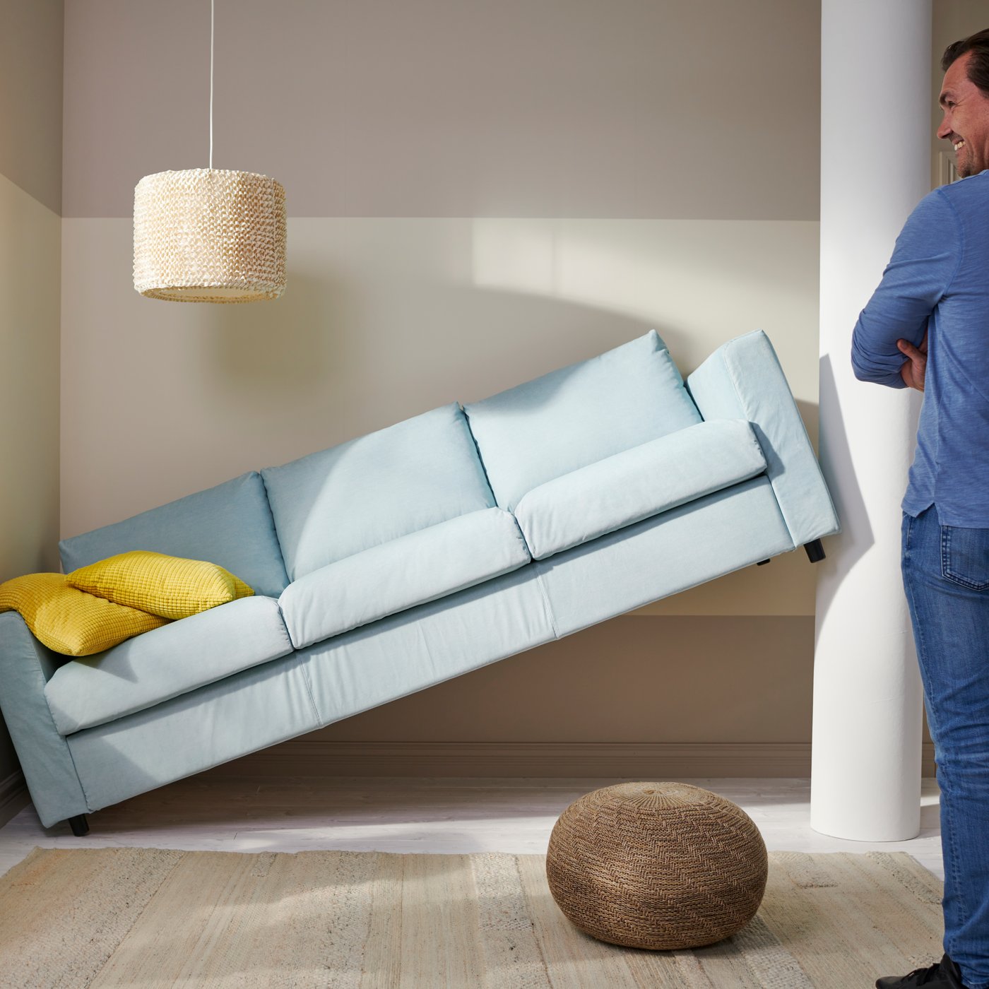 A man looking at their new sofa that doesn’t fit into the intended space and has to be returned.