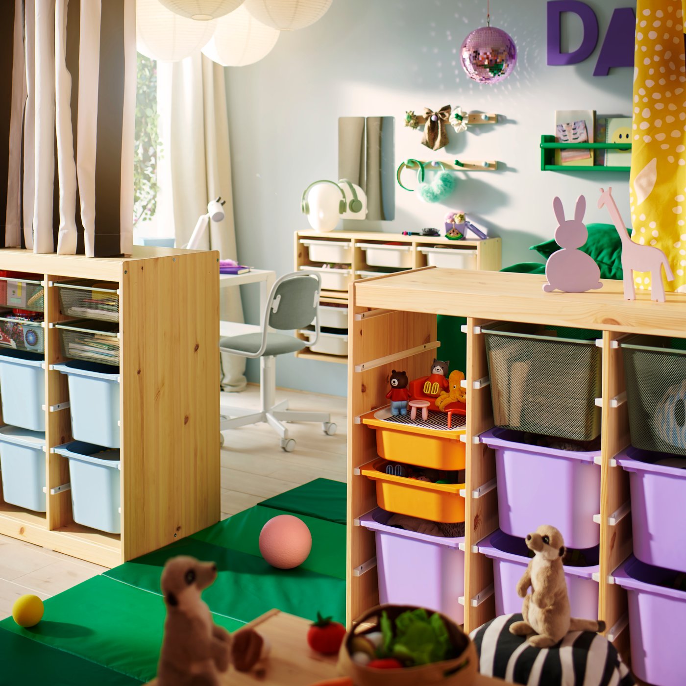 Två ljusa, vitbetsade TROFAST rumsavdelare i furu rymmer varsin uppsättning färgade lådor i ett delat barnrum.
