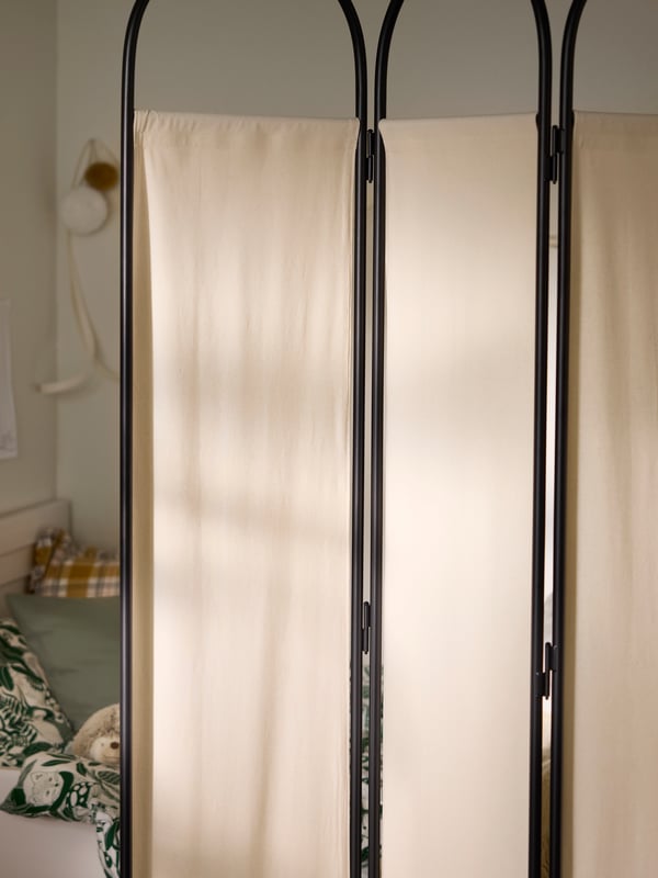 Detalle del separador de ambientes GRÅFJÄLLET en carbón con tejido beige.