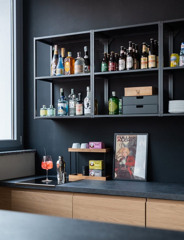 Un angolo del bar arredato con sistema METOD composto da uno scaffale e mobili con piani di lavoro neri.