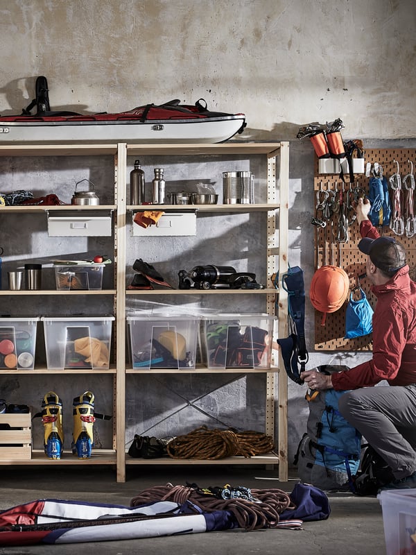 Plastic and wooden boxes, cardboard boxes and baskets inside BROR shelving unit organizing a garage wall.