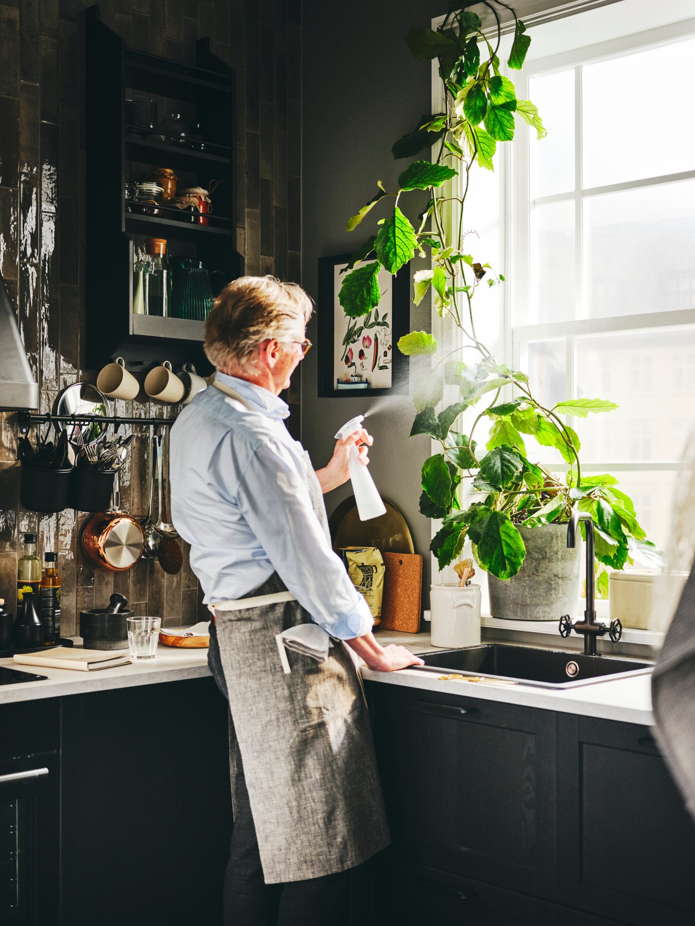 Person som sprayar sina växter med en sprayflaska.