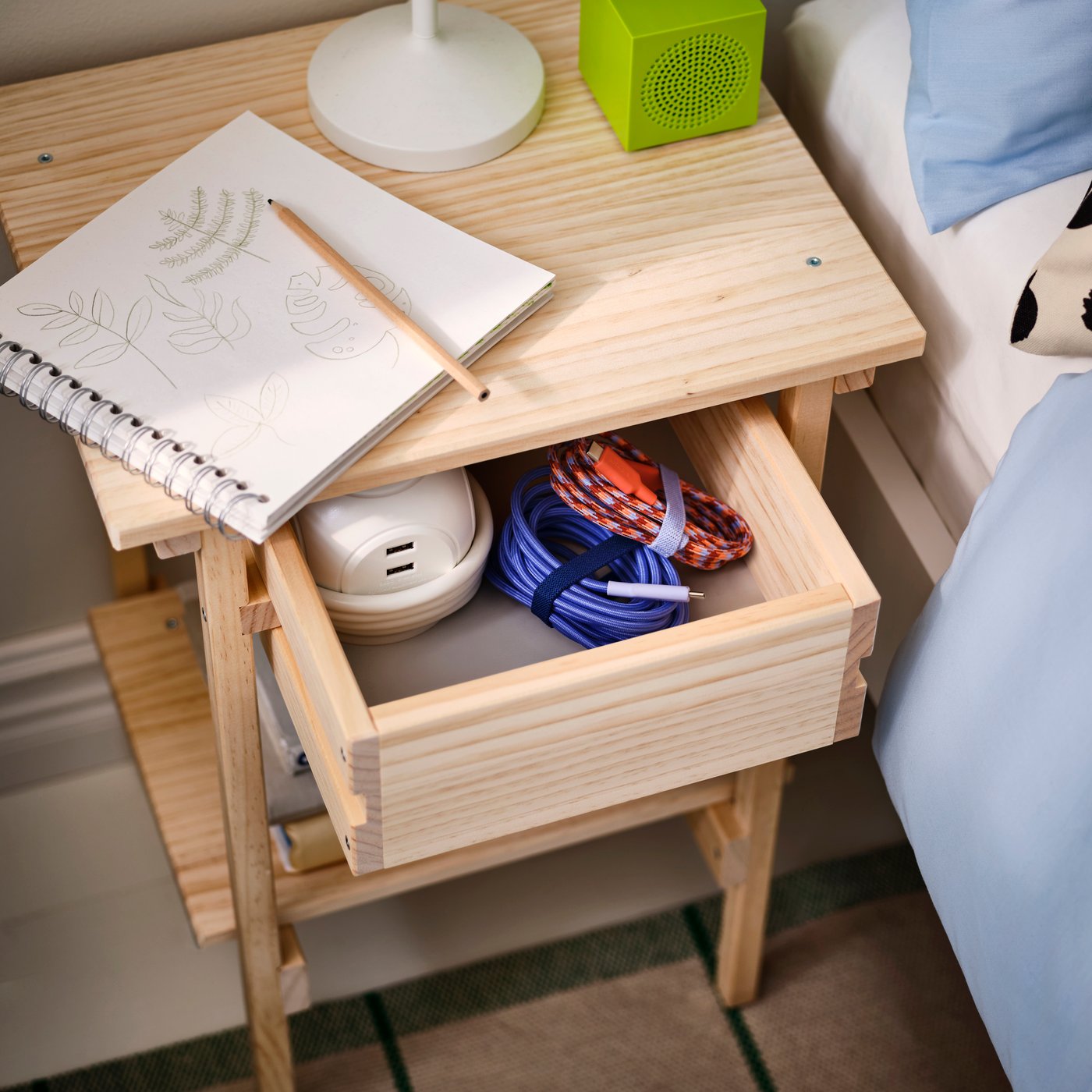 A pine KRONÖREN bedside table in the bedroom