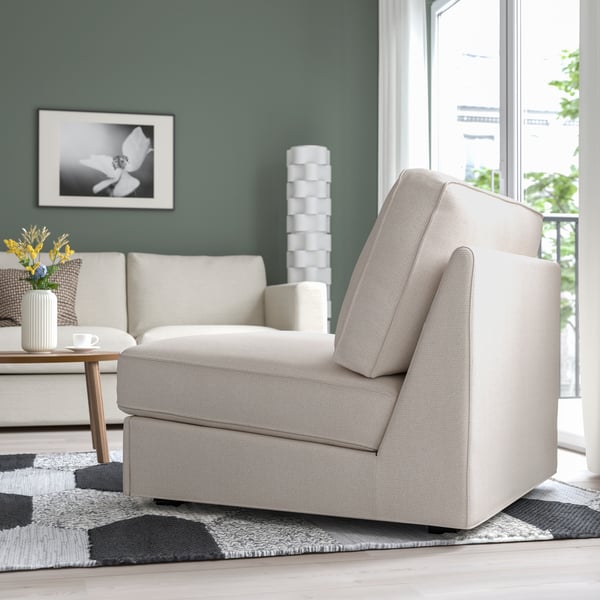 Weiße Récamiere und Sofa auf gemustertem Teppich im Wohnzimmer, minzgrüne Tapete und Couchtisch.