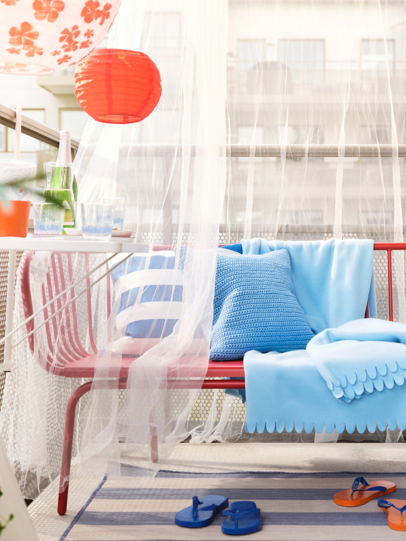 Una terraza con una cortina de velos cubriendo un sofá de terraza. 