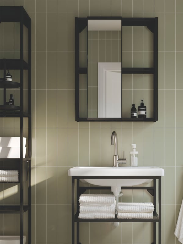 ENHET badkamer in antraciet met open planken en een kast met een spiegeldeur staat tegen een grijsgroene wand.