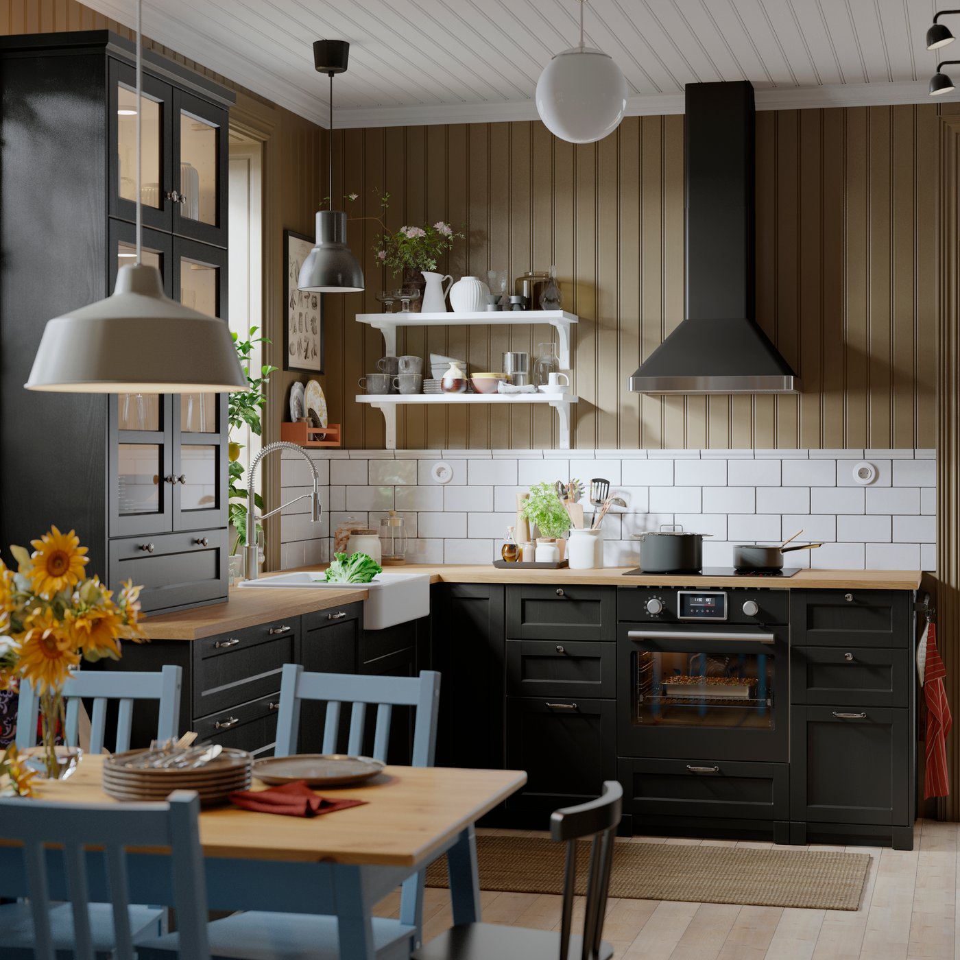 A kitchen with a black STENABY true fan oven is positioned beneath a sleek extractor hood, surrounded by cabinets and a sink.