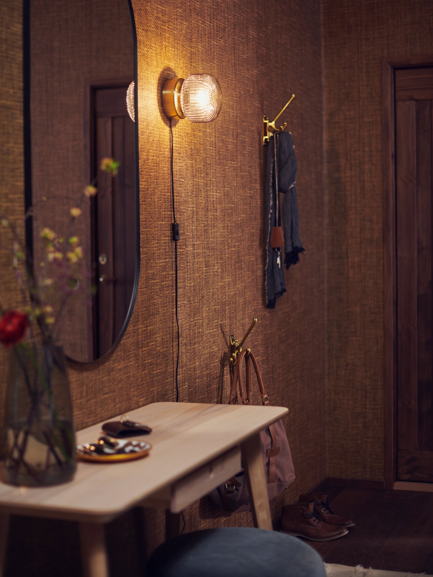 A brass/grey clear glass SOLKLINT wall lamp in the hallway