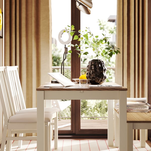 An ÅLHULT extendable table, with a bench and two chairs, is placed next to a sliding door that leads to a sunny backyard.