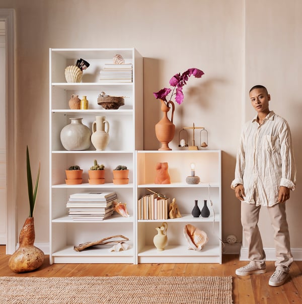 two billy bookcases and a person standing next to them