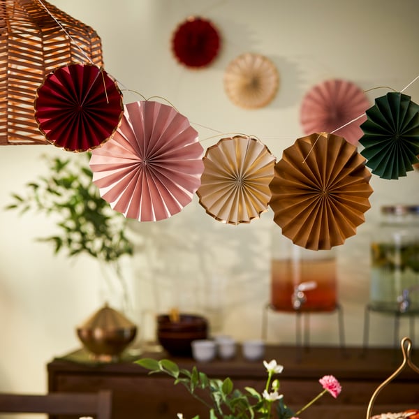 A colourful and festive GOKVÄLLÅ hang deco, hanging in the ceiling of a beautifully decorated living room.