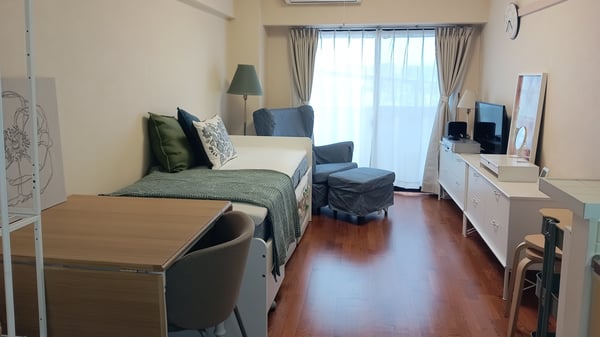 部屋の左側にデスクとベッド、右側にはチェストと導線が確保された家具の配置。