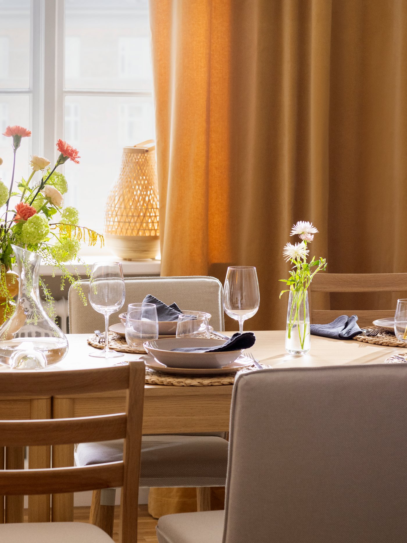 A TONSTAD table in oak veneer and TONSTAD chairs, the table set with glasses and tableware for a festive occasion.