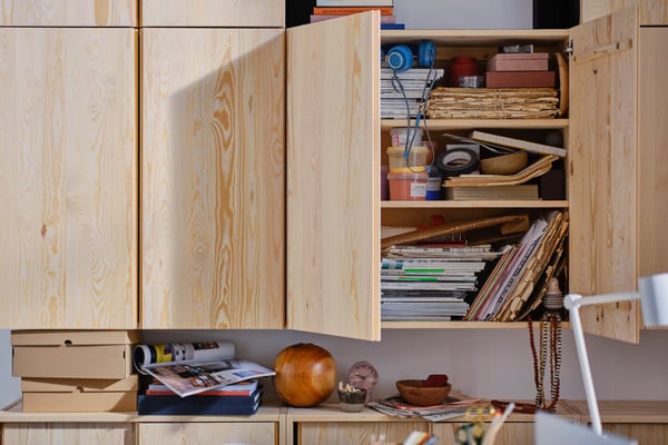 Two wooden IVAR cabinets. The open cabinet shows a lot of clutter. With IKEA's tips, you can say goodbye to your mess.