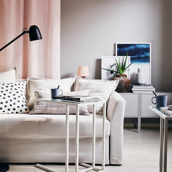 a living room with a white sofa and a white VITTSJÖ laptop stand