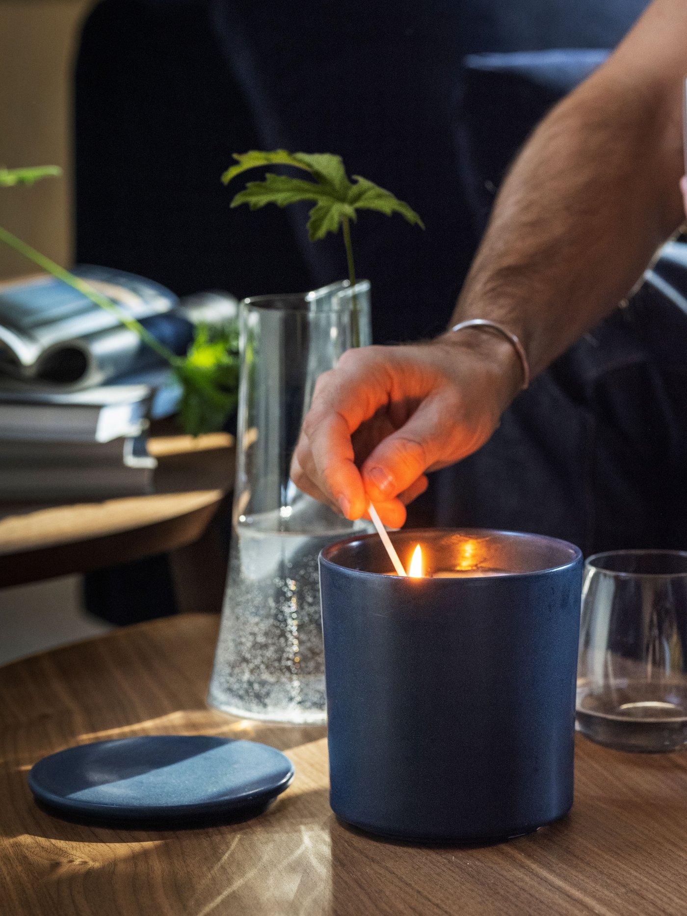 A FRUKTSKOG scented candle in a glass jar on a table set for relaxation